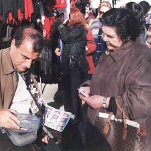 Vendedor de lotería de la ONCE con una clienta en el Rastro de Aranjuez