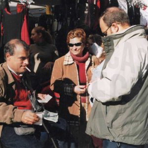 Vendedor de lotería de la ONCE con unos clientes en el Rastro de Aranjuez