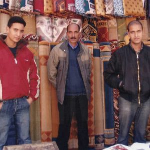 Tres vendedores en un puesto de alfombras en el Rastro de Aranjuez