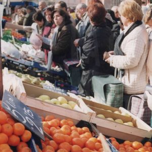 Varias personas en un puesto de frutas en el Rastro de Aranjuez