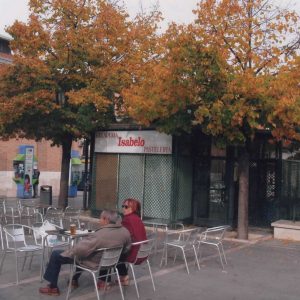 Dos personas en la terraza del Kiosko Isabelo rodeado de tilos en la Plaza de la Constitución de Aranjuez