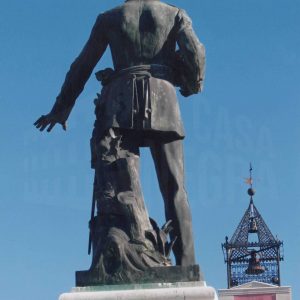 Vista posterior de la estatua de Alfonso XII en la Plaza de la Constitución de Aranjuez, con la torre del Ayuntamiento al fondo