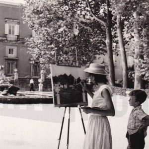 Una pintora pinta un cuadro en el Jardín del Parterre de Aranjuez y un niño la observa