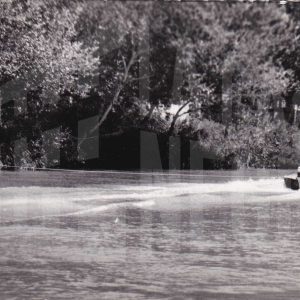 Lancha con gente surcando el río Tajo y haciendo esquí acuático cerca del Puente Barcas, en Aranjuez