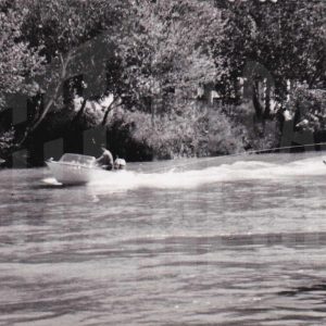 Lancha con gente surcando el río Tajo y haciendo esquí acuático cerca del Puente Barcas, en Aranjuez