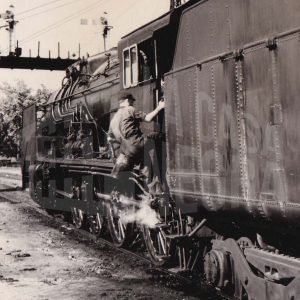 Maquinista subiendo a una locomotora de carbón