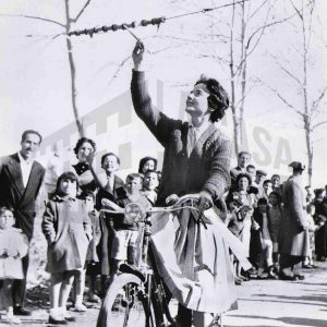 Señora en bicicleta en un concurso de habilidades en la fábrica de MAFE (Manufacturas Fotográficas Españolas) en Aranjuez