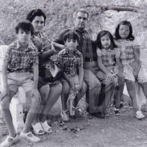 Unos padres con sus cuatro hijos posan sentados en un banco en Aranjuez. Familia Marín