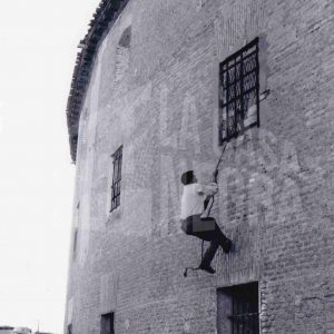 Una persona trepando con una cuerda por la fachada de la Plaza de Toros de Aranjuez para colarse en un espectáculo