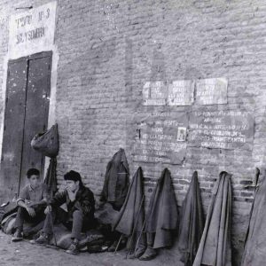 Dos maletillas fuman sentados esperando una oportunidad a las puertas de la Plaza de Toros de Aranjuez