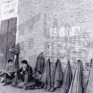 Dos maletillas fuman sentados esperando una oportunidad a las puertas de la Plaza de Toros de Aranjuez