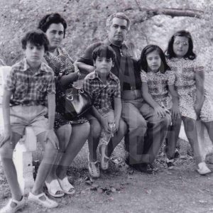 Unos padres con sus cuatro hijos posan sentados en un banco en Aranjuez. Familia Marín