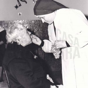 Una monja da de comer uvas a una anciana durante una celebración de Fin de Año en Aranjuez