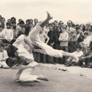 Dos jóvenes yudocas luchan en el tatami rodeados de público durante juegos escolares en Aranjuez