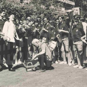 Banda musical formada por niños de Bilbao tocan sus instrumentos alrededor de un limpiabotas en Aranjuez