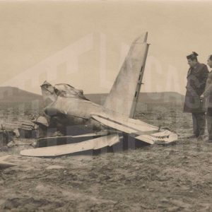 Un guardia civil y otra persona observan los restos de una avioneta accidentada