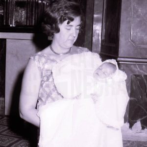 Una señora con un bebé en una iglesia durante un bautizo