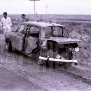 Cinco  personas junto a un coche accidentado en una cuneta en Seseña