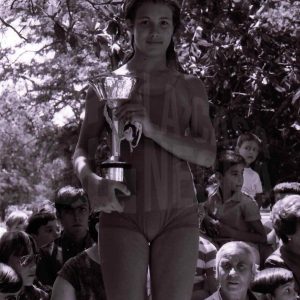 Una nadadora de la 1ª Travesía del Tajo en Aranjuez con su trofeo