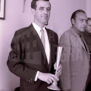 El ganador de unas partidas simultáneas de ajedrez posa con su trofeo junto a otro hombre