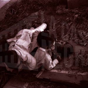 Tres niños jugando entre cartones y paja en Aranjuez