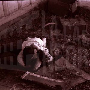 Dos niños jugando entre cartones y paja en Aranjuez