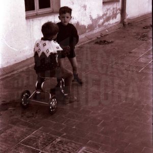 Dos niños con un triciclo