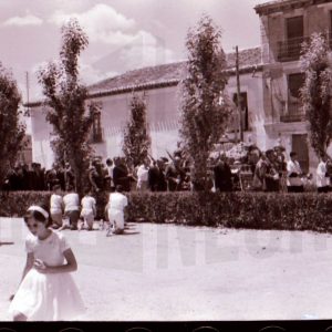 Soldado y otras personas arrodilladas presentando armas en la procesión del Corpus Christi en Aranjuez