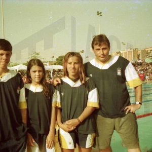 José Luis Talavera con tres nadadores en una piscina