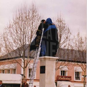 Un trabajador cubre la escultura del rey Fernando VI en Aranjuez