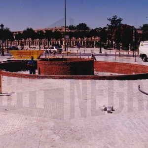 Obras de construcción de la fuente en la Plaza de Santiago Rusiñol en Aranjuez con las Casas de Oficios y Caballeros y la Plaza de San Antonio al fondo