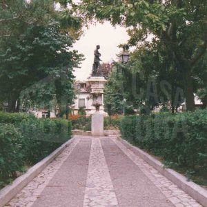 Perspectiva de los jardines y uno de los paseos en la Plaza de la Constitución de Aranjuez, con la escultura de Alfonso XII al fondo