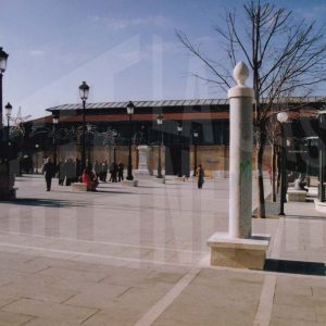 Varias  personas en la Plaza de la Constitución de Aranjuez con el Mercado de Abastos al fondo