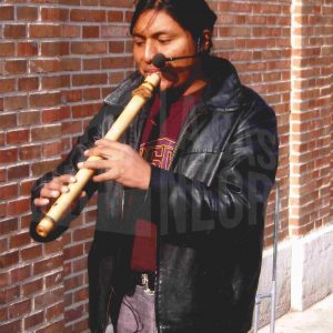 Un músico ambulante toca una flauta junto al Mercado de Abastos en Aranjuez