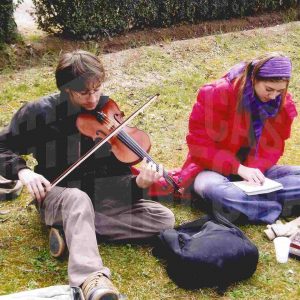 Un chico toca el violín y una chica dibuja en el Jardín de la Isla  en Aranjuez