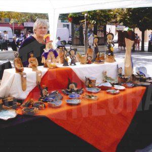 Una mujer en un puesto de artesanía en un Rastrillo en la Plaza de la Constitución en  Aranjuez