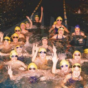 Varias nadadoras y nadadores en una piscina