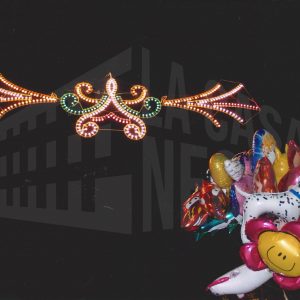 Un manojo de globos bajo una guirnalda de luces durante las fiestas de San Fernando en Aranjuez