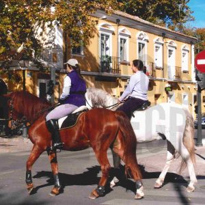 Dos mujeres a caballo por la calle Príncipe en Aranjuez