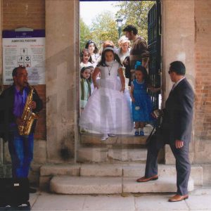 Una niña vestida de comunión junto a otras personas sale del Jardín del Parterre en Aranjuez