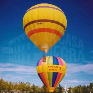 Varias personas junto a dos globos aerostáticos cautivos en la Plaza de San Antonio en Aranjuez