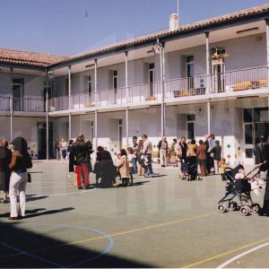 Varias personas en el patio de la corrala del Colegio Público Vicente Aleixandre en la Calle Príncipe de Aranjuez