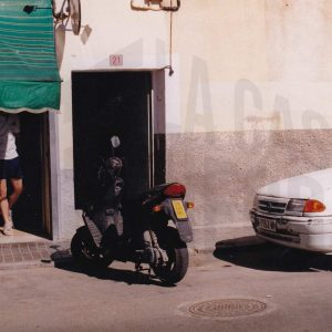 Vehículos aparcados frente a la entrada a una corrala en la Calle Calandria en Aranjuez