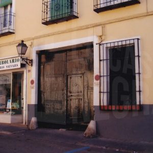 Edificio en la Calle San Pascual de Aranjuez con puerta de entrada a una corrala y un herbolario