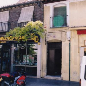 Edificio en la Calle Stuart en Aranjuez con la puerta de entrada a una corrala y varios comercios