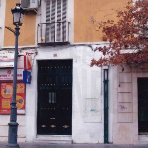 Edificio en la Calle Stuart en Aranjuez con la puerta de entrada a una corrala y varios comercios de fotografía