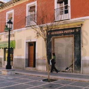 Edificios en la Calle Postas de Aranjuez con varios comercios y la puerta de entrada a una corrala de Aranjuez