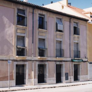 Edificios en la Calle Postas de Aranjuez con un comercio y la puerta de entrada a una corrala