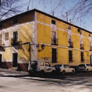 Edificio en la esquina de las calles Montesinos y Gobernador en Aranjuez con la puerta de entrada a una corrala