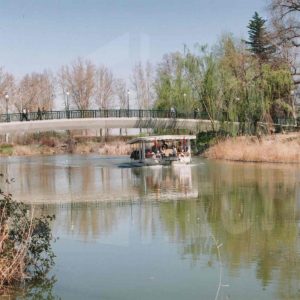 Barco turístico navegando sobre el río Tajo y bajo el nuevo puente de El Castillo, en el Jardín del Príncipe de Aranjuez